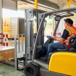 Un hombre de DHL Expres opera un montacargas