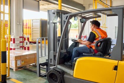 Un hombre de DHL Expres opera un montacargas