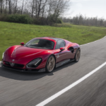 Alfa Romeo 33 Stradale rojo circula en una carretera de curvas, símbolo de la deportividad y diseño italiano de la marca.