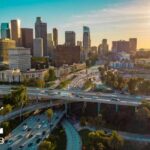 Vista aérea de una zona urbana con autopistas, tráfico vehicular y edificios de gran altura utilizada por Geotab para ilustrar un estudio de movilidad vial.
