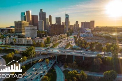 Vista aérea de una zona urbana con autopistas, tráfico vehicular y edificios de gran altura utilizada por Geotab para ilustrar un estudio de movilidad vial.
