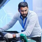 Técnico automotriz inspecciona el sistema de un vehículo durante una competencia internacional de habilidades de posventa.