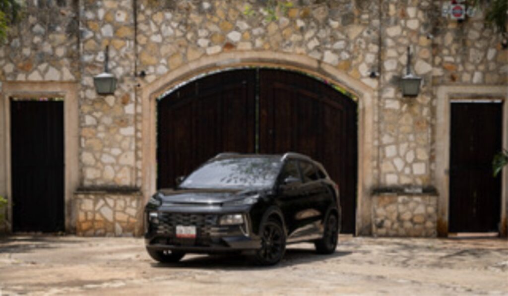 JAC 6 PHEV color negro estacionado frente a una fachada de piedra con puertas de madera de estilo colonial