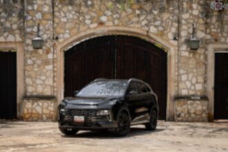 JAC 6 PHEV color negro estacionado frente a una fachada de piedra con puertas de madera de estilo colonial