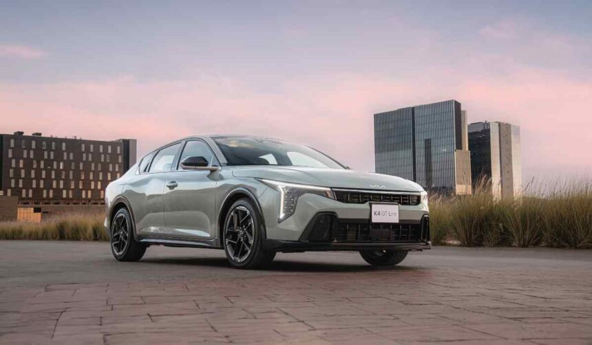 Kia K4 color gris plata estacionado en un entorno urbano durante el atardecer, modelo fabricado en México y reconocido por su calidad inicial en el estudio J.D. Power 2026.