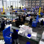 Personal opera un centro logístico con sistemas de clasificación y embalaje para productos sensibles a la temperatura dentro de una instalación de distribución.