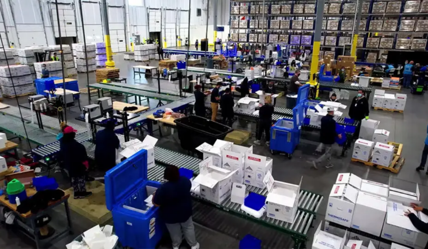 Personal opera un centro logístico con sistemas de clasificación y embalaje para productos sensibles a la temperatura dentro de una instalación de distribución.
