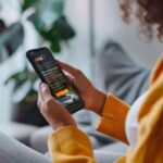 Persona utilizando una aplicación móvil para gestionar servicios de movilidad y arrendamiento vehicular desde su teléfono inteligente.