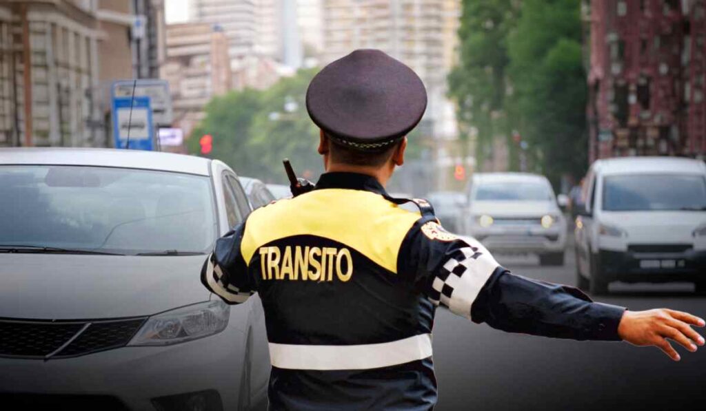 Agente de tránsito dirige la circulación vehicular en una avenida de la Ciudad de México, donde aumentará el número de oficiales autorizados para aplicar multas de tránsito.