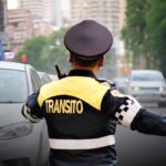 Agente de tránsito dirige la circulación vehicular en una avenida de la Ciudad de México, donde aumentará el número de oficiales autorizados para aplicar multas de tránsito.