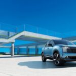 Nissan Kicks 2026 color azul estacionado en un complejo arquitectónico moderno durante su presentación en Japón