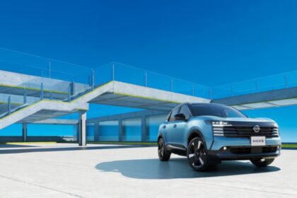 Nissan Kicks 2026 color azul estacionado en un complejo arquitectónico moderno durante su presentación en Japón