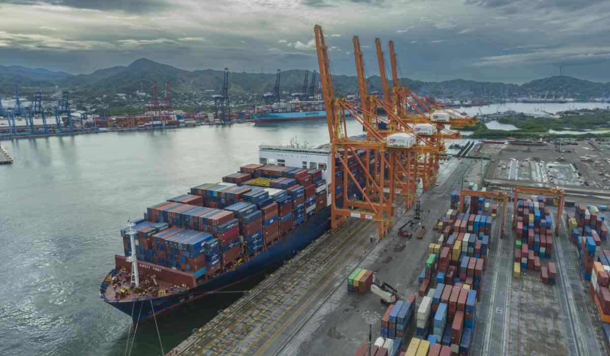 Buque portacontenedores atracado en una terminal del Puerto de Manzanillo junto a grúas pórtico y patios de almacenamiento de contenedores.