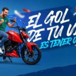 Persona celebrando sobre una motocicleta TVS roja durante la campaña promocional El gol de tu vida es tener una TVS