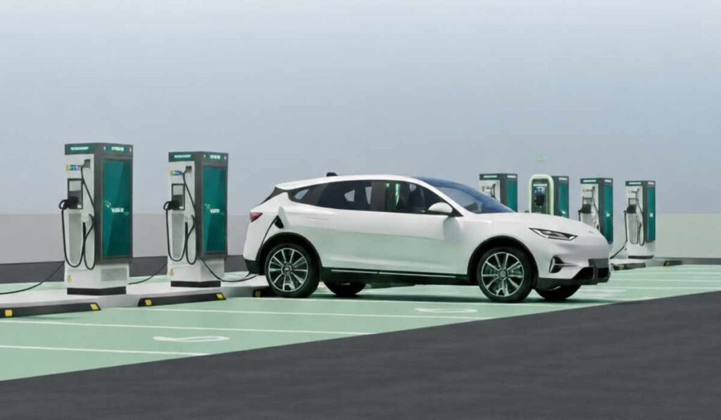 Vehículo eléctrico blanco conectado a una estación de carga rápida en un hub de recarga de VEMO con múltiples cargadores disponibles.