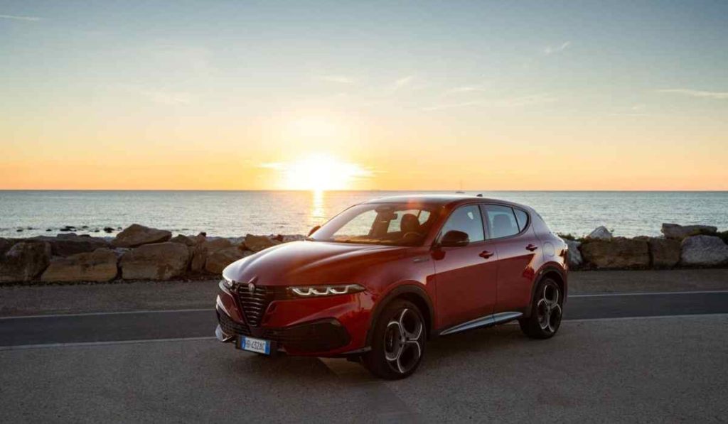 Alfa Romeo Junior rojo frente al mar durante un atardecer de verano