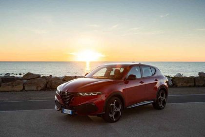 Alfa Romeo Junior rojo frente al mar durante un atardecer de verano