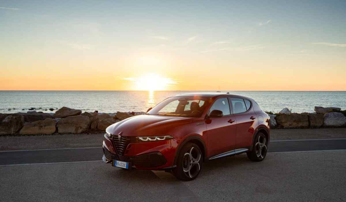 Alfa Romeo Junior rojo frente al mar durante un atardecer de verano