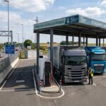 Estación de carga para vehículos pesados con camiones eléctricos junto a una carretera