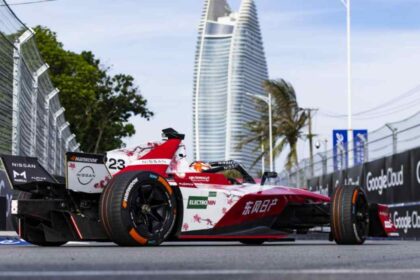 Monoplaza Nissan e-4ORCE 05 número 23 de Norman Nato durante el E-Prix de Sanya, China, con un rascacielos y palmeras al fondo.