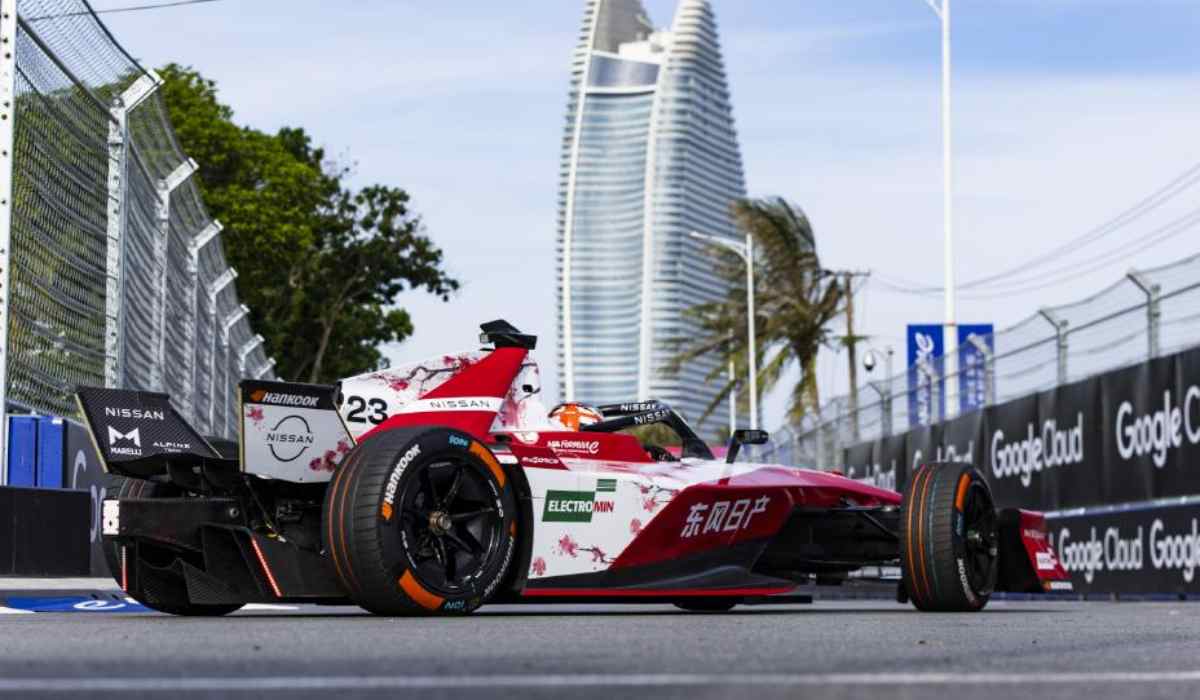 Monoplaza Nissan e-4ORCE 05 número 23 de Norman Nato durante el E-Prix de Sanya, China, con un rascacielos y palmeras al fondo.