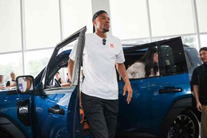 Giannis Antetokounmpo junto al SUV híbrido JETOUR G700 durante una visita a las instalaciones de la marca en China.