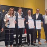 Grupo de directivos posando con reconocimientos de SoyLogístico durante evento corporativo sobre un escenario.