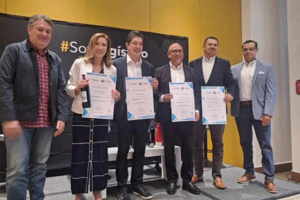 Grupo de directivos posando con reconocimientos de SoyLogístico durante evento corporativo sobre un escenario.