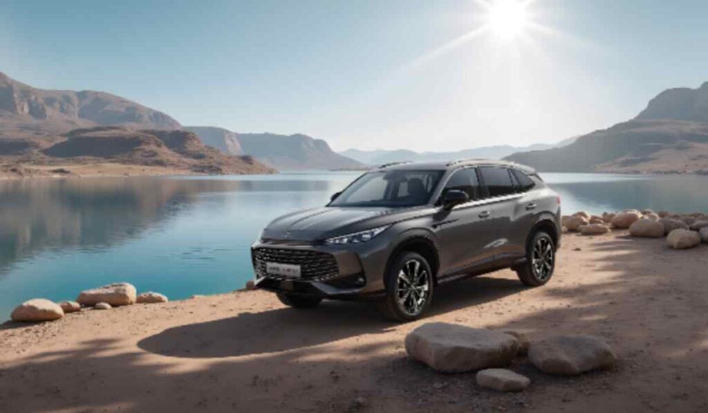 SUV MG gris junto a un lago rodeado de montañas