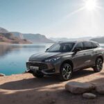 SUV MG gris junto a un lago rodeado de montañas