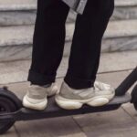 Persona de pie sobre un scooter eléctrico urbano utilizado para movilidad personal en calles de la Ciudad de México.