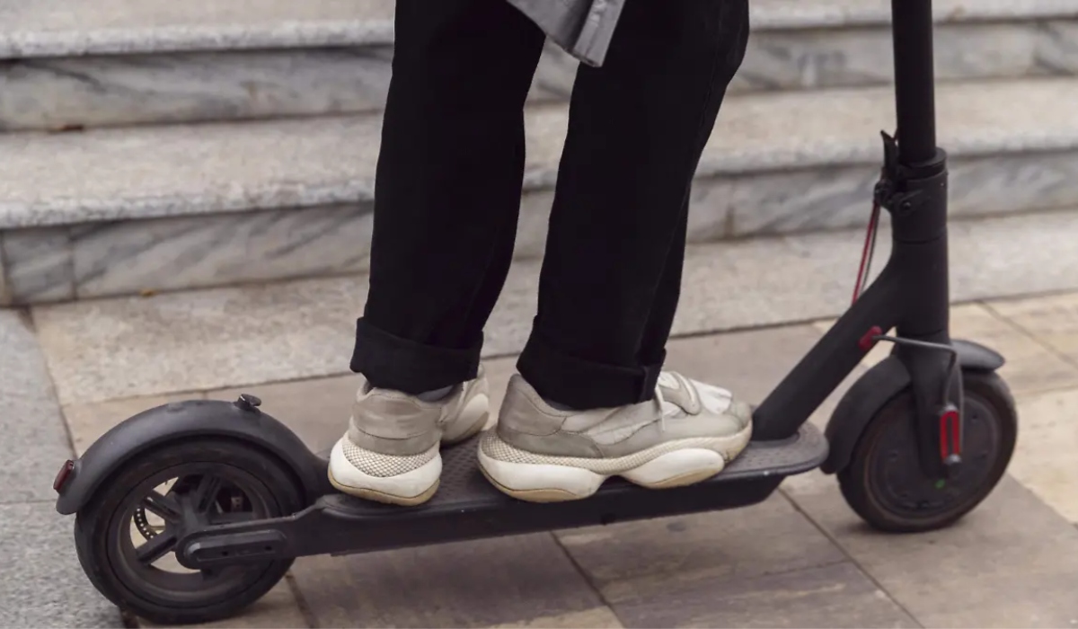 Persona de pie sobre un scooter eléctrico urbano utilizado para movilidad personal en calles de la Ciudad de México.