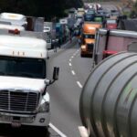 Fila de camiones pesados de carga circula por una carretera en México durante un periodo de recuperación de la producción y las exportaciones del sector.