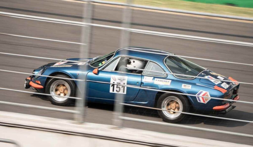 Automóvil deportivo clásico azul número 151 corriendo en el Autódromo Hermanos Rodríguez durante el Gran Premio Histórico