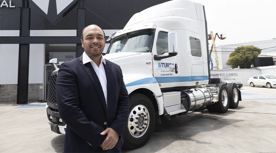 Rodrigo Arcos, de Fruehauf, junto a un tractocamión International LT de TUMSA durante la entrega de la unidad 150