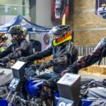 Motociclistas con casco integral y equipo de protección participan en una actividad de seguridad vial durante el Salón Internacional de la Motocicleta México.