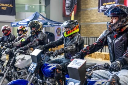 Motociclistas con casco integral y equipo de protección participan en una actividad de seguridad vial durante el Salón Internacional de la Motocicleta México.