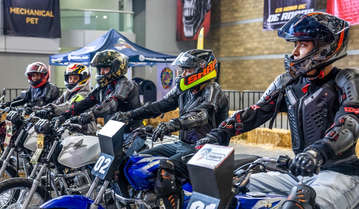 Motociclistas con casco integral y equipo de protección participan en una actividad de seguridad vial durante el Salón Internacional de la Motocicleta México.