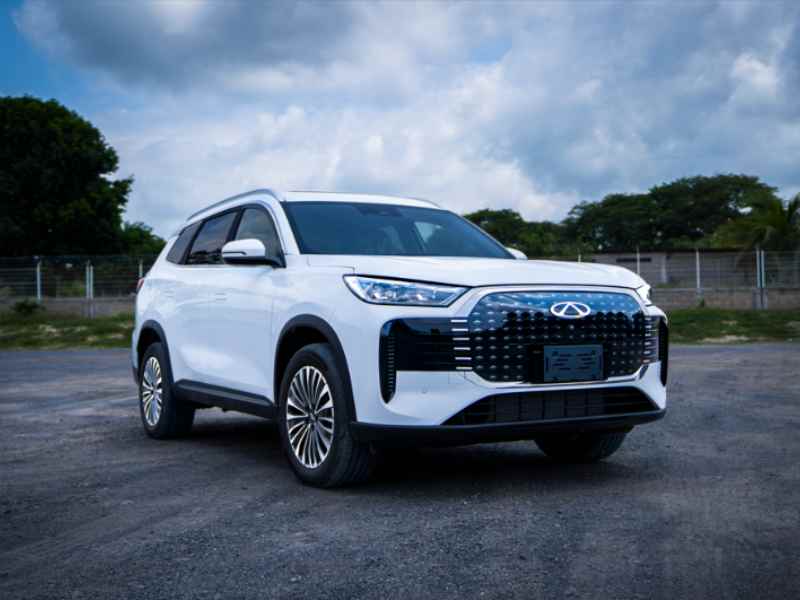 SUV Chirey Tiggo PHEV de color blanco con parrilla frontal de diseño diamante e iluminación LED, estacionada al aire libre.