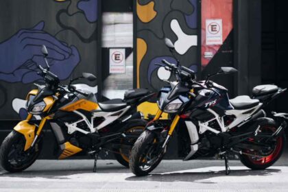 Dos motocicletas deportivas TVS Apache RTR 310 en colores amarillo y azul estacionadas frente a un mural urbano.