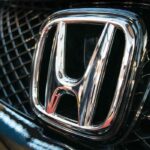 Emblema cromado de Honda en la parrilla frontal de un auto, representando las decisiones de inversión de la automotriz japonesa ante la revisión del T-MEC en Norteamérica.