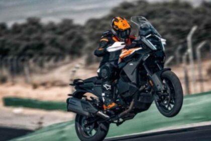 Motociclista con equipo de protección realizando un wheelie en una motocicleta KTM touring en pista, representando el arquetipo de conductor viajero y competitivo.