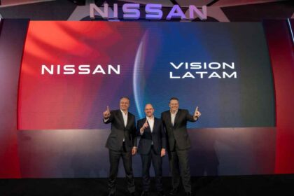 Tres ejecutivos de Nissan en el escenario apuntando hacia arriba frente a una pantalla con la inscripción Nissan Vision Latam.