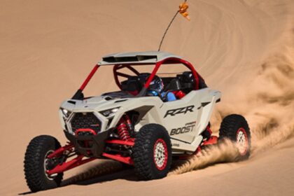 Polaris RZR Pro R Boost 2027 circulando a alta velocidad sobre dunas de arena en una prueba de desempeño off-road.