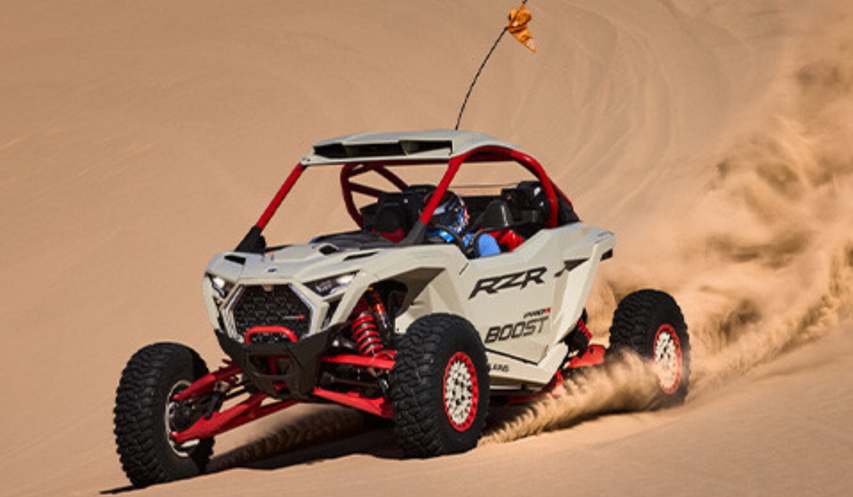 Polaris RZR Pro R Boost 2027 circulando a alta velocidad sobre dunas de arena en una prueba de desempeño off-road.