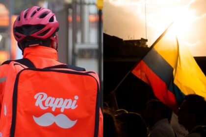 Repartidor de Rappi con mochila naranja junto a la bandera de Colombia iluminada por el sol, en el marco de donaciones por el terremoto.
