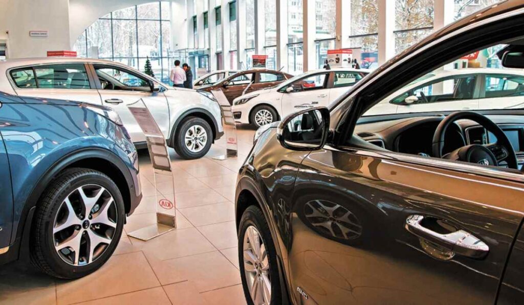 Vehículos nuevos exhibidos en el interior de una concesionaria automotriz durante la venta de automóviles.