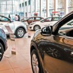 Vehículos nuevos exhibidos en el interior de una concesionaria automotriz durante la venta de automóviles.