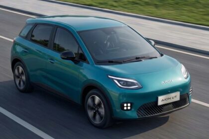 Vehículo eléctrico compacto GAC AION UT en color verde turquesa circulando sobre el asfalto.