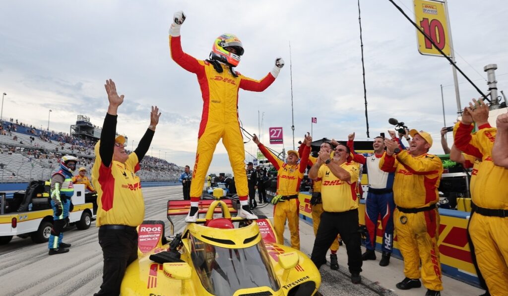 Alex Palou celebra de pie sobre su monoplaza de Chip Ganassi Racing junto a su equipo tras ganar su quinto campeonato de IndyCar.